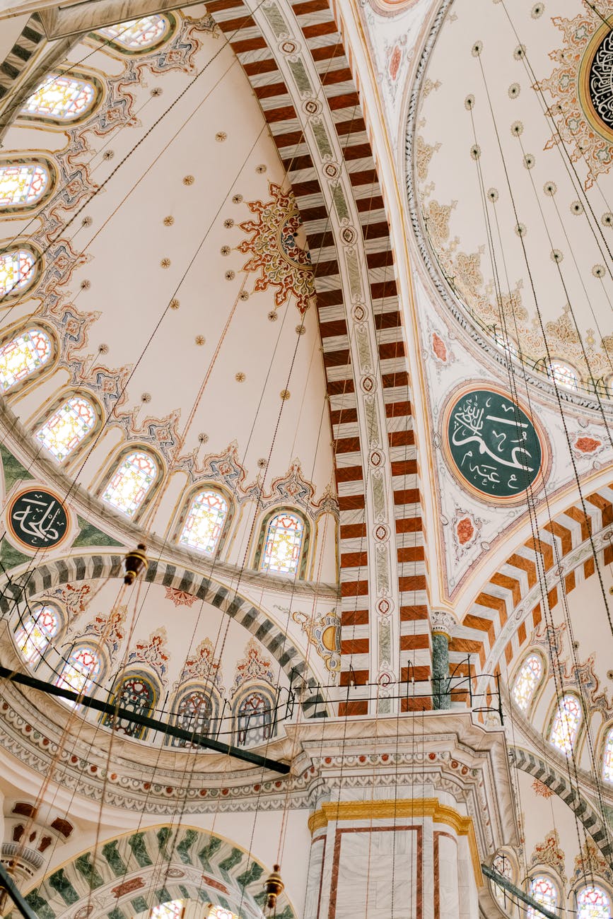 ornamental ceiling of islam medieval mosque with arched windows
