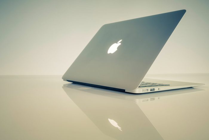 silver macbook on white table
